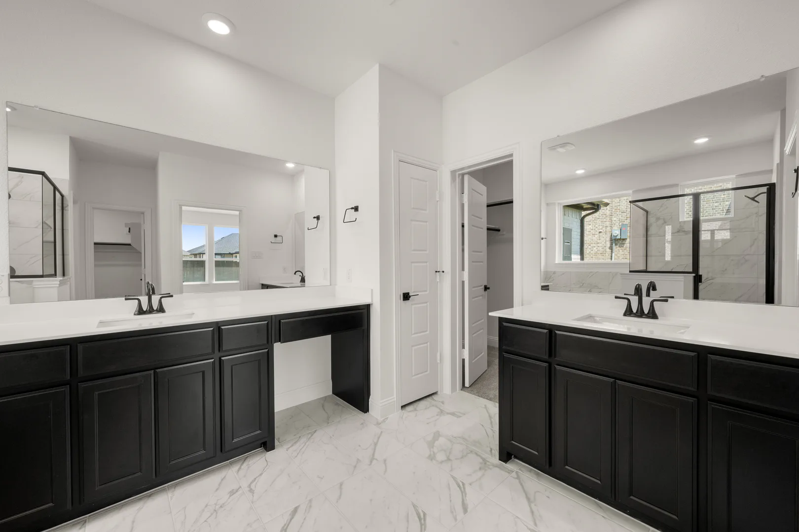 Primary bathroom with dual vanities in a new traditional style home by Kindred Homes