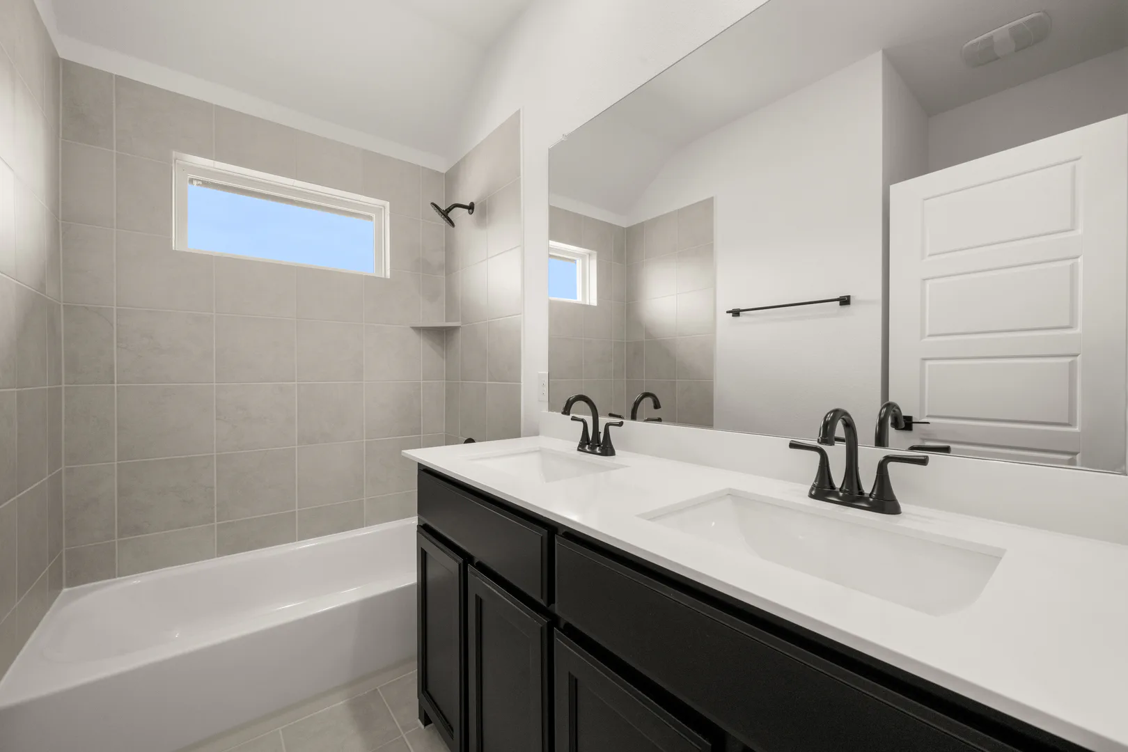 Secondary bathroom with dual vanity and shower/tub combo.