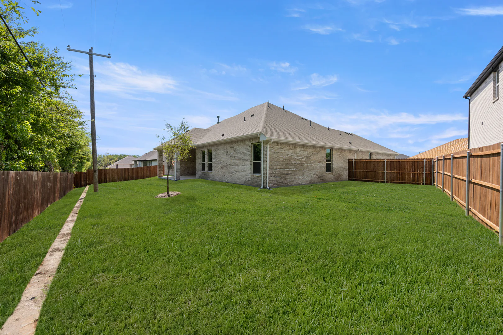 Spacious backyard of a transitional ranch style home by Kindred Homes