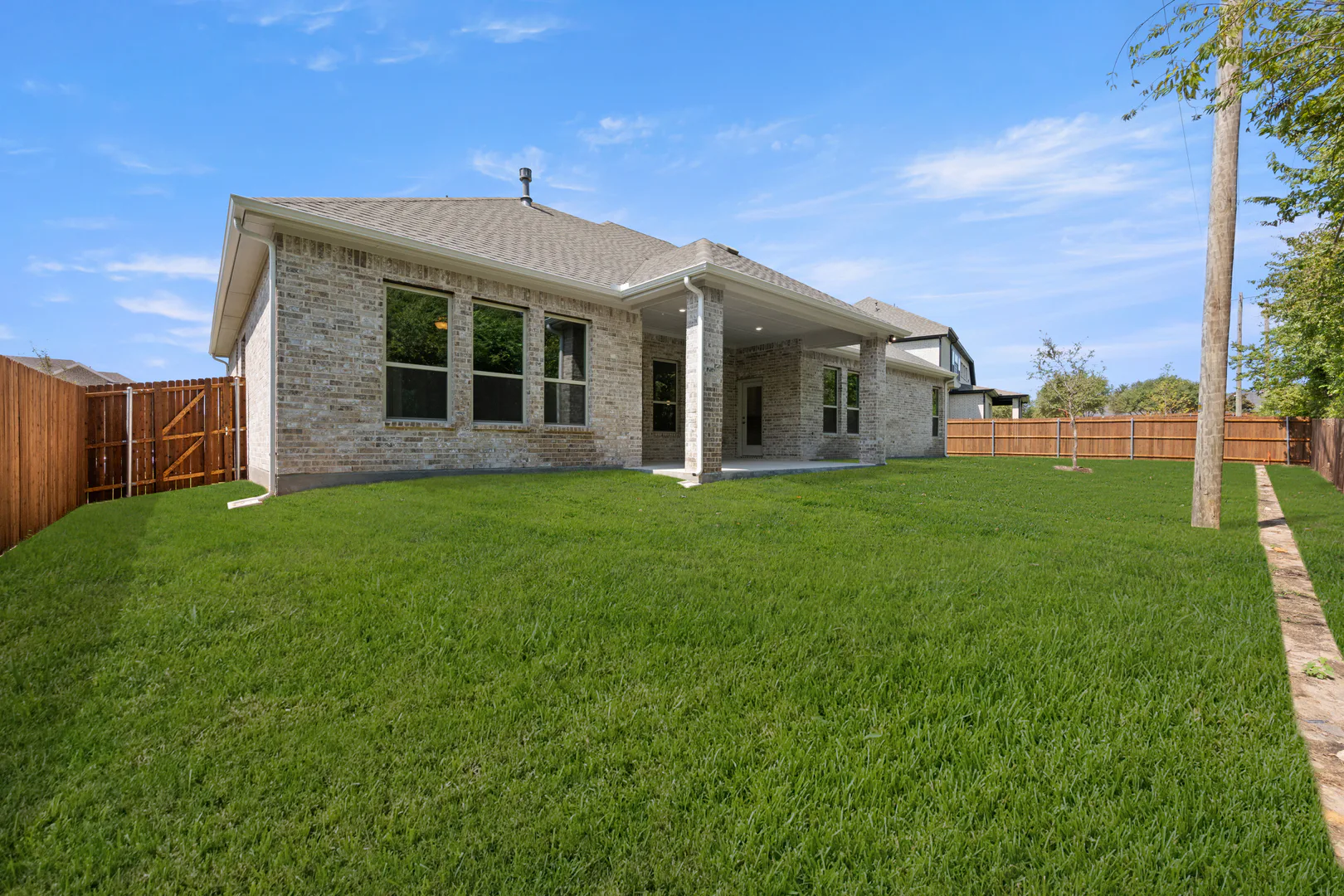Spacious backyard of a transitional ranch style home by Kindred Homes