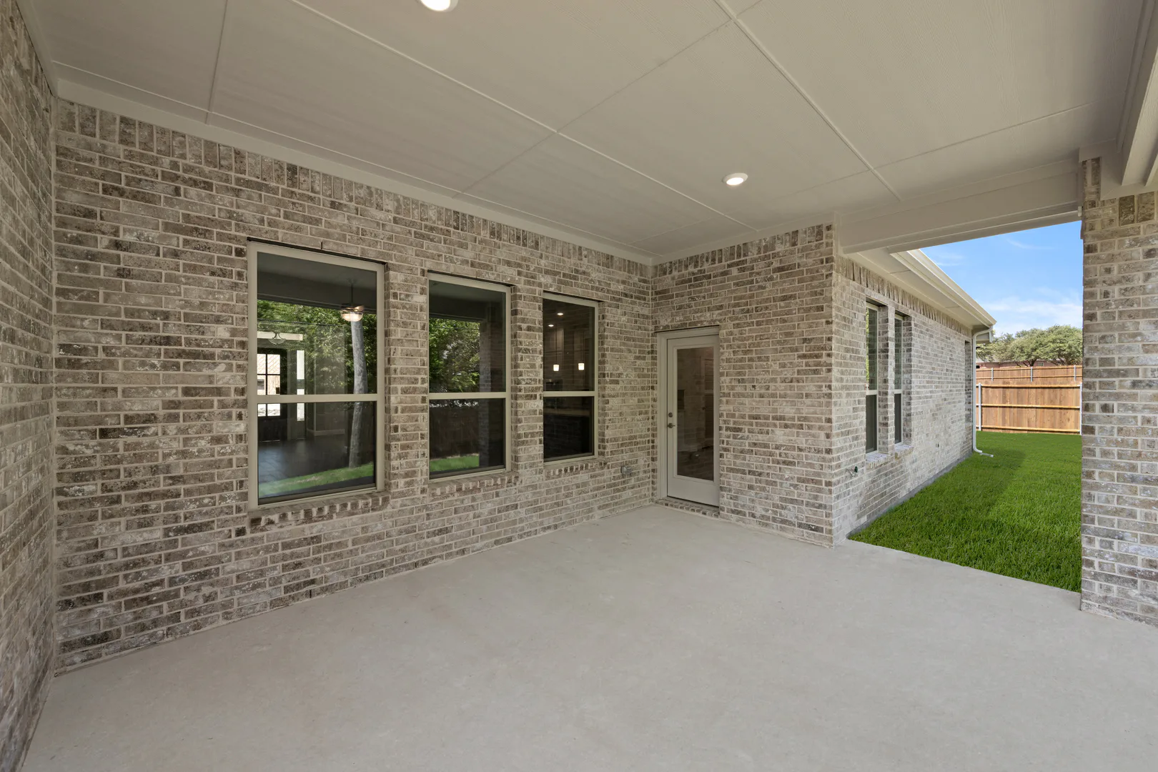 Covered patio in a transitional ranch style home by Kindred Homes