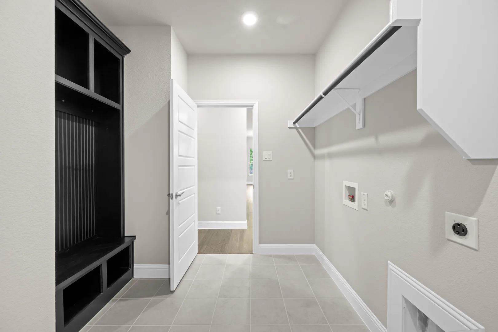 Utility and mud room in a transitional ranch style home by Kindred Homes
