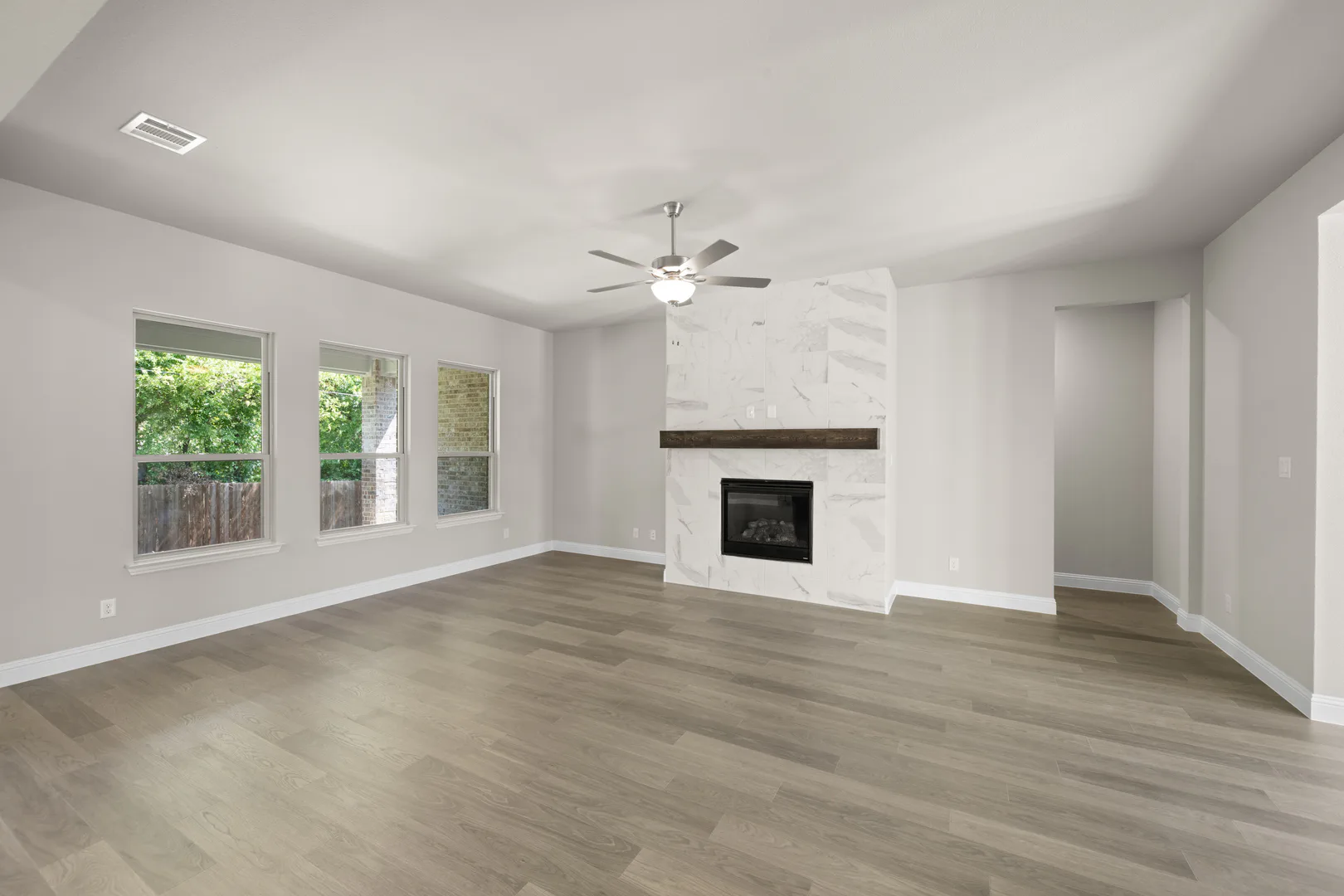 Living room with fireplace in a transitional ranch style home by Kindred Homes