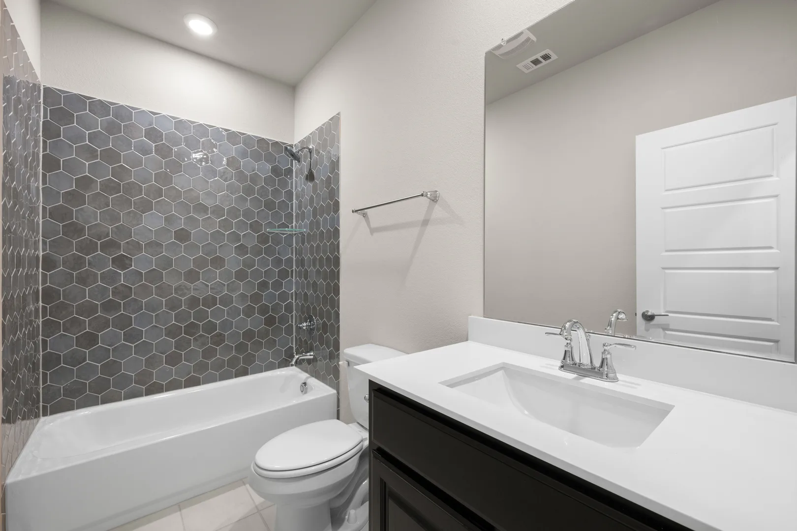 Secondary bathroom with shower/tub in a transitional ranch style home by Kindred Homes