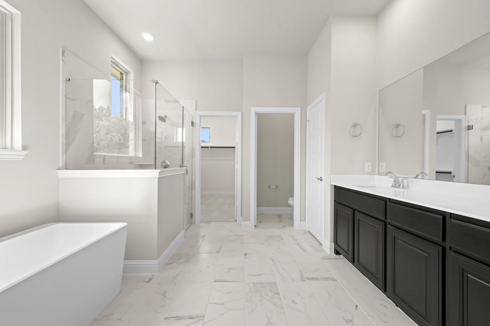 Primary bathroom in a transitional ranch style home by Kindred Homes