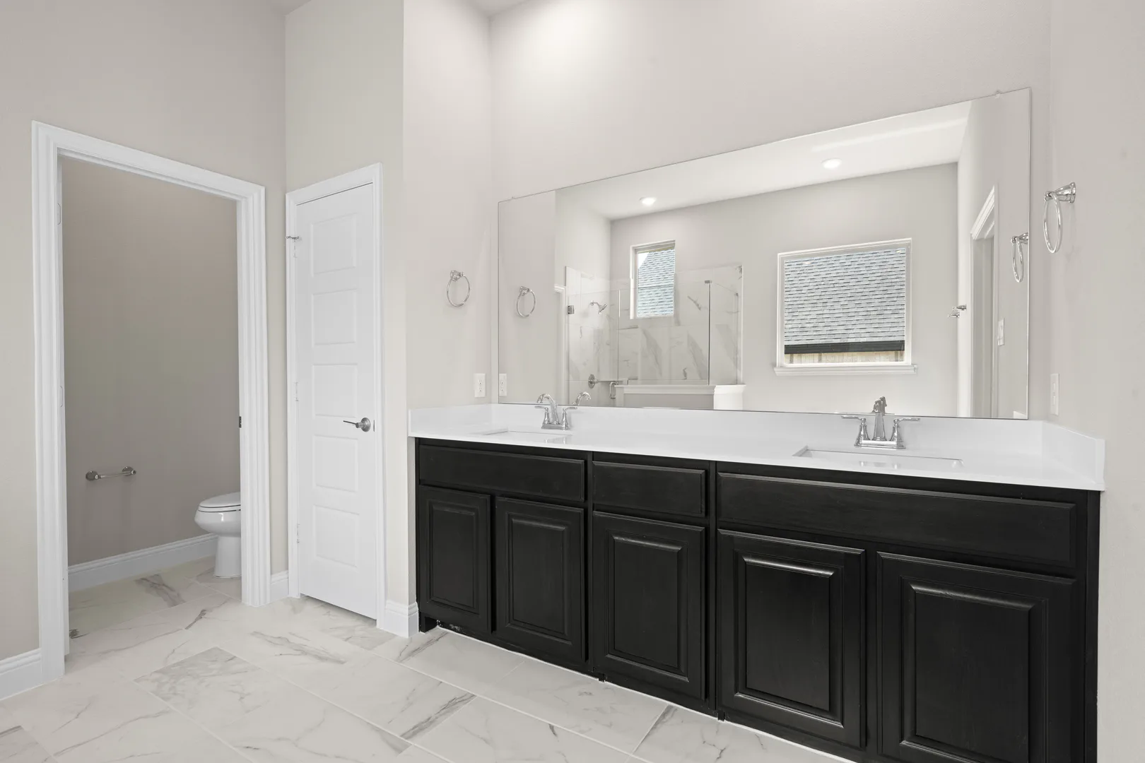 Primary bathroom with dual vanity in a transitional ranch style home by Kindred Homes