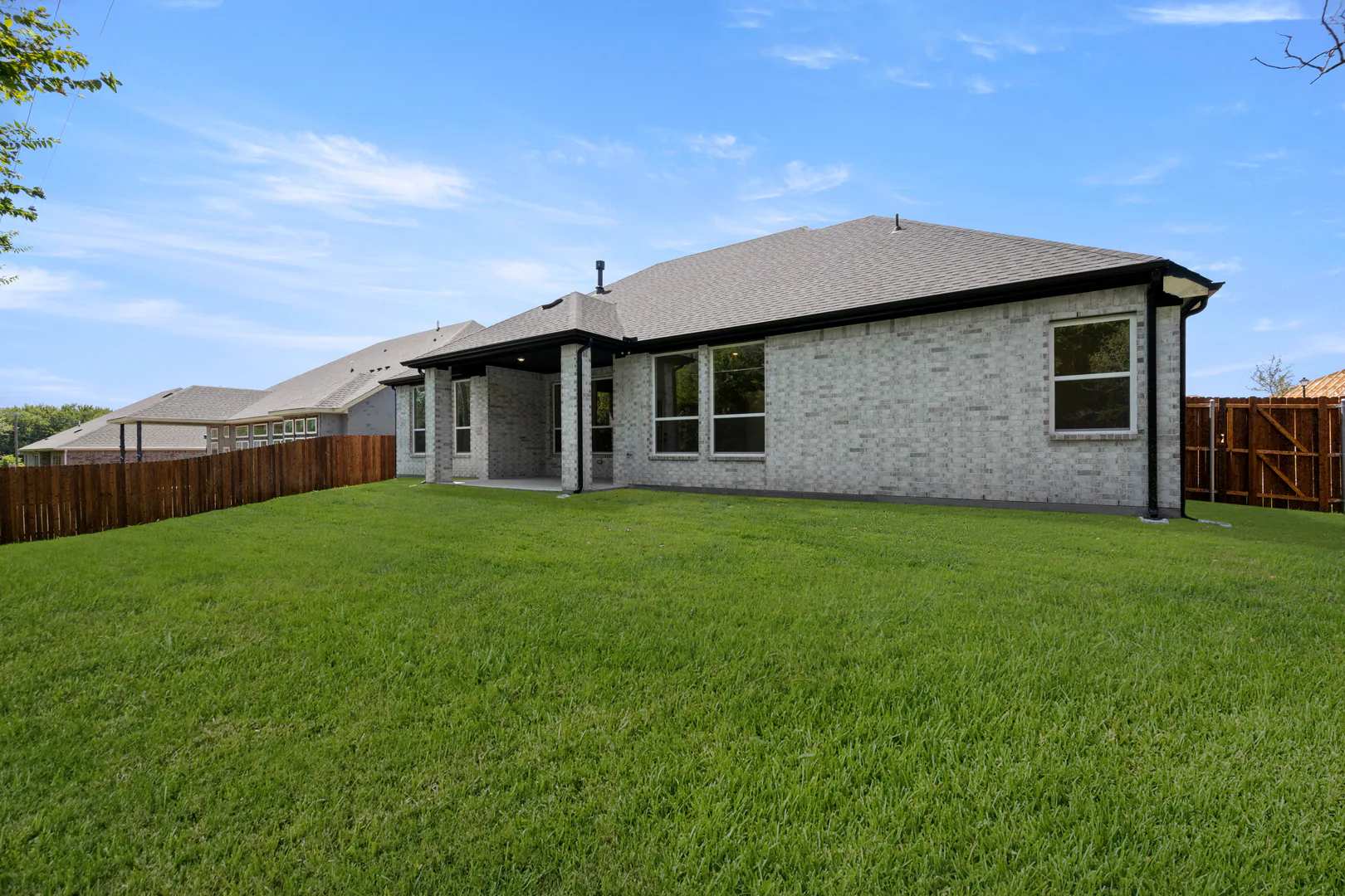 Spacious backyard of a transitional ranch style home by Kindred Homes