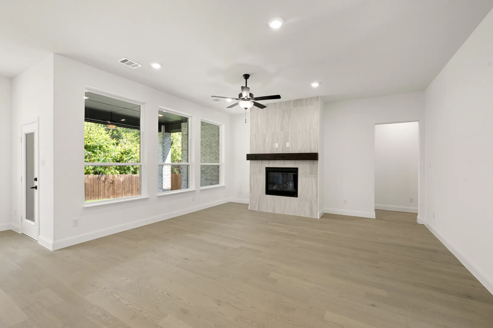 Living room with fireplace in a transitional ranch style home by Kindred Homes
