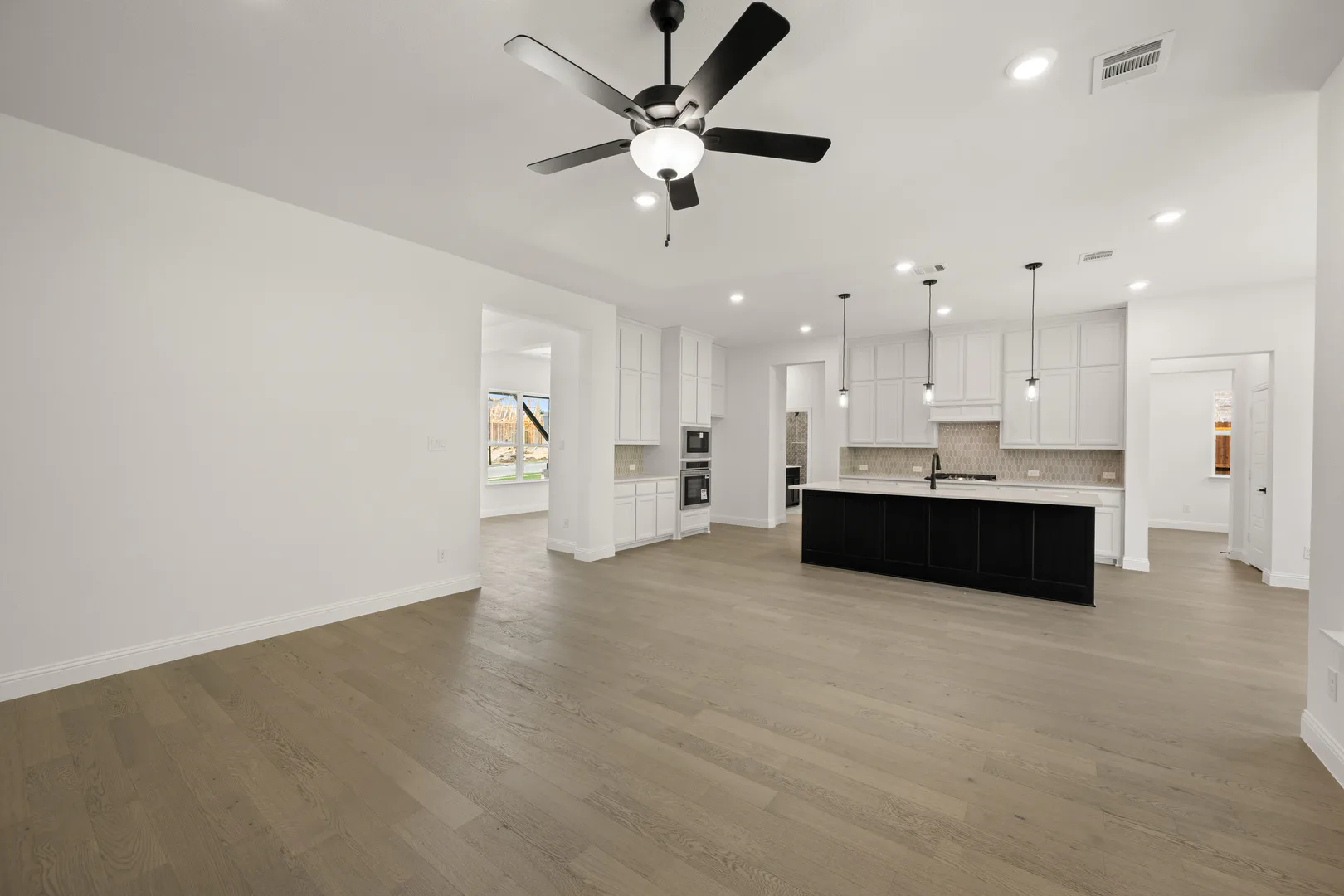 Living room and kitchen in a transitional ranch style home by Kindred Homes