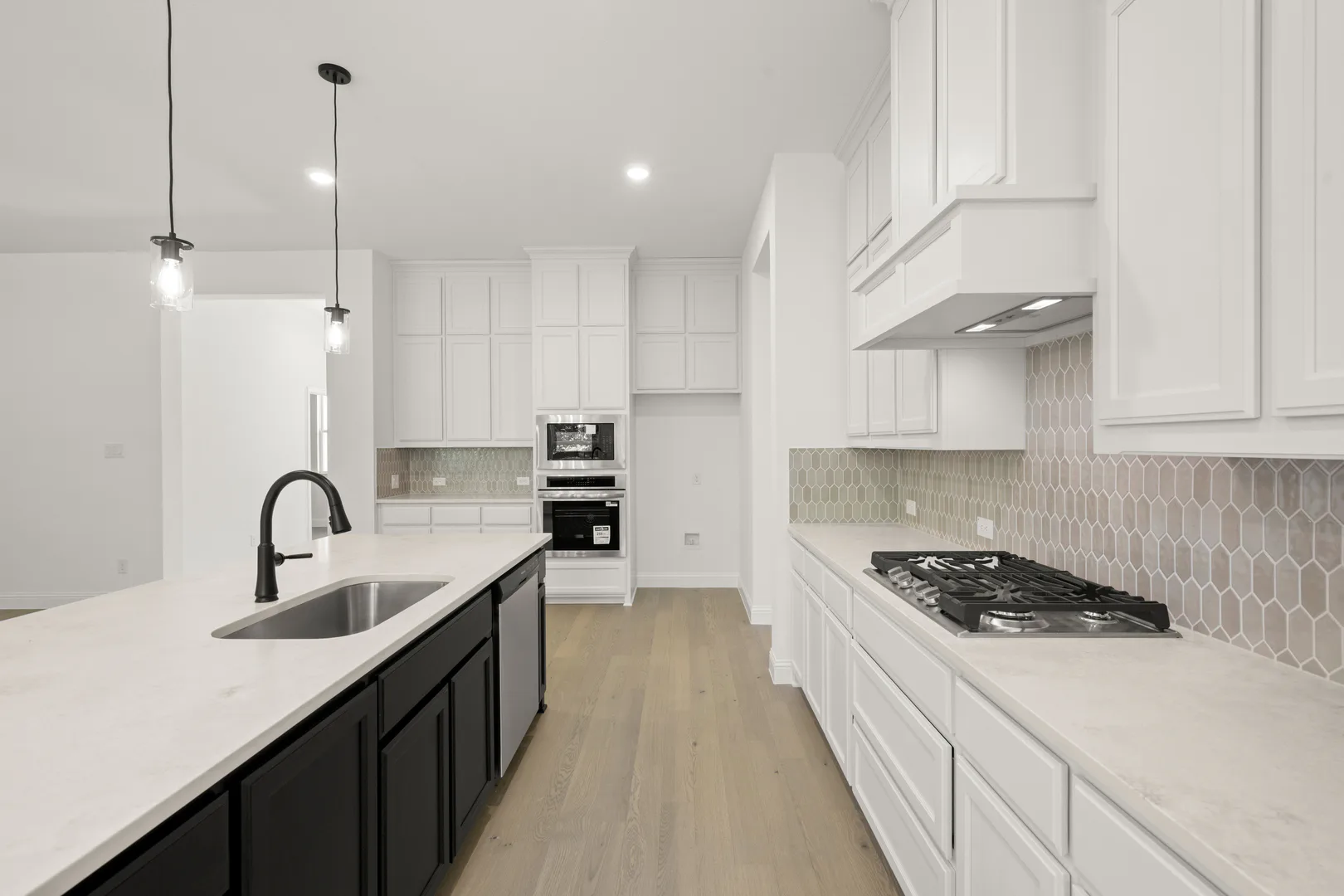 Kitchen with stainless steel appliances in a transitional ranch style home by Kindred Homes