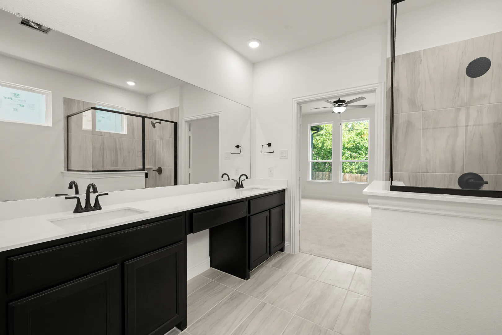 Primary bathroom with dual vanity in a transitional ranch style home by Kindred Homes