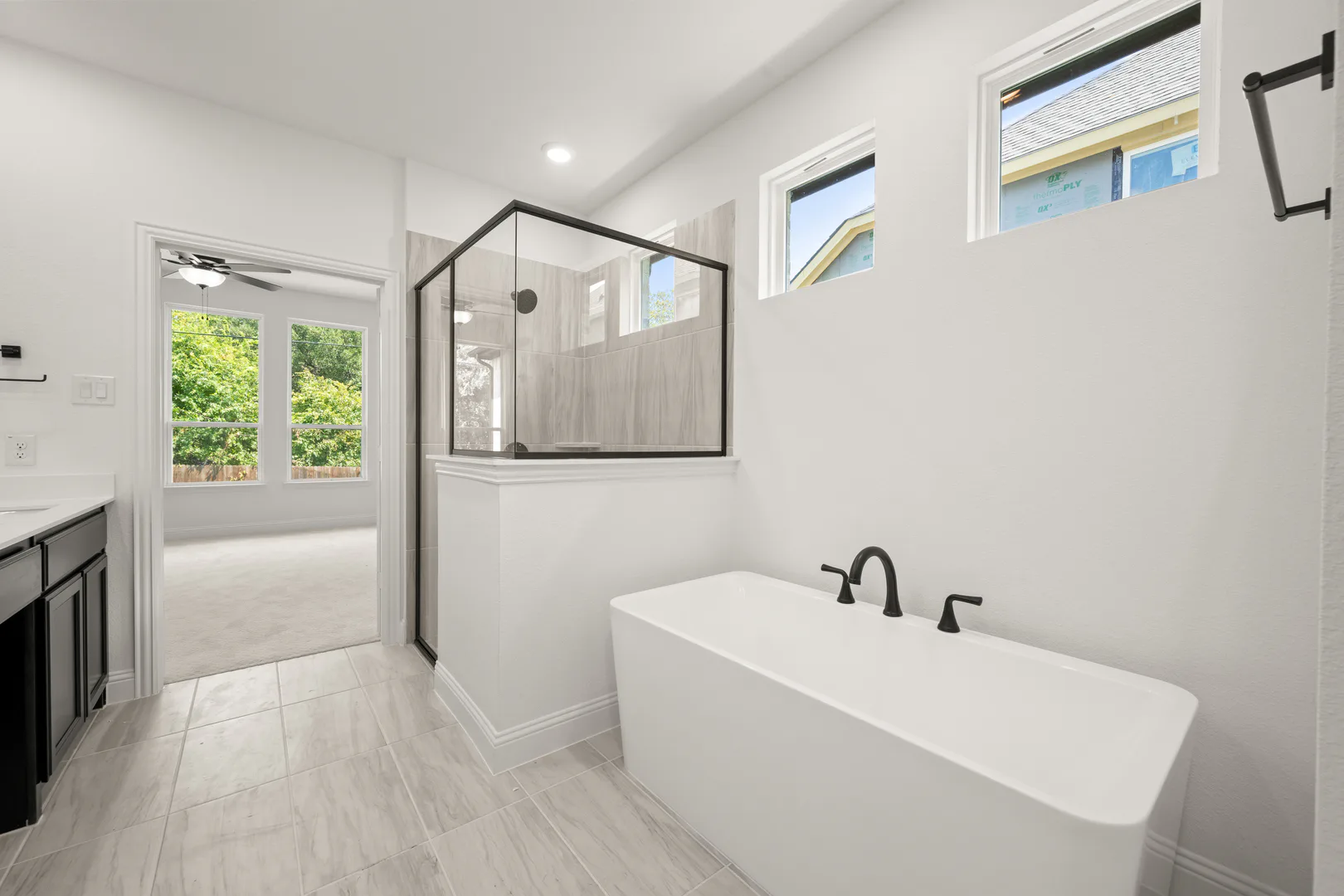 Primary bathroom with freestanding tub and walk-in shower in a transitional ranch style home by Kindred Homes