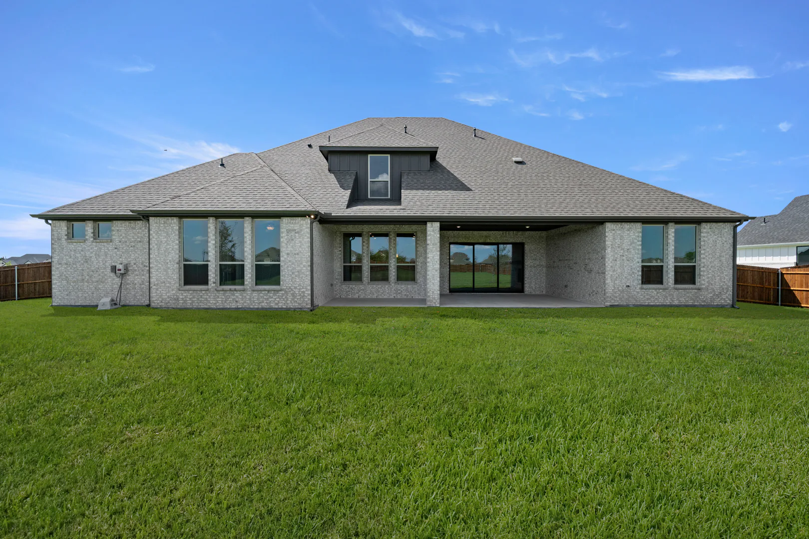 Spacious backyard of a modern Texas ranch style home by Kindred Homes