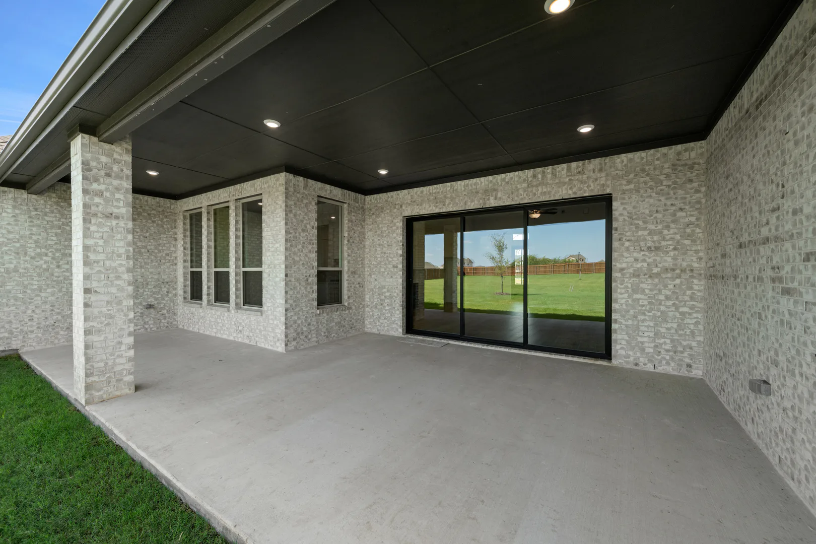 Large covered patio in a modern Texas ranch style home by Kindred Homes