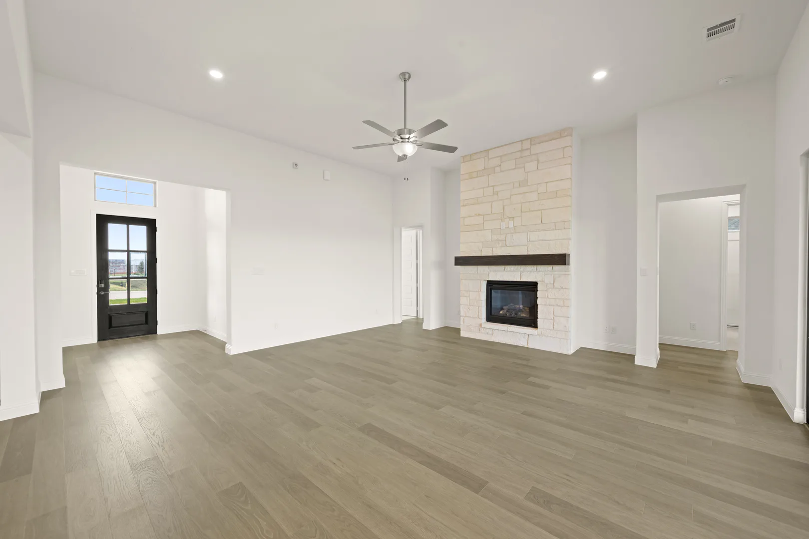 Living room with fireplace in a modern Texas ranch style home by Kindred Homes