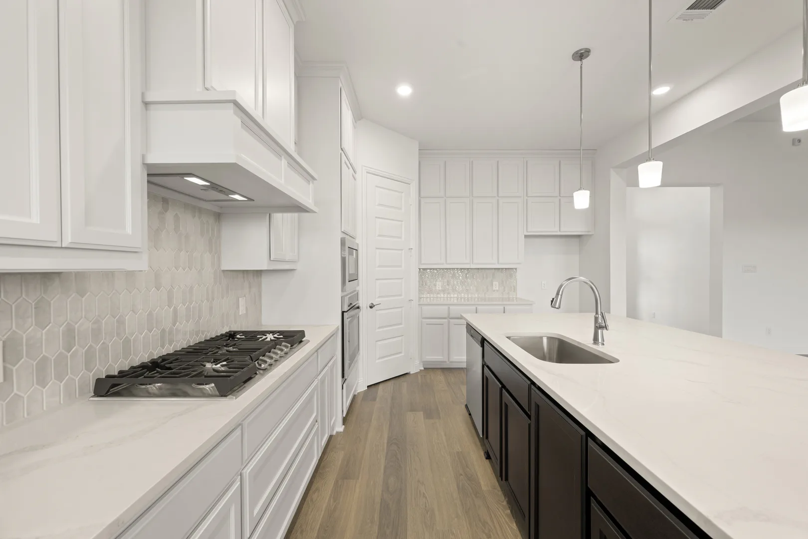 Kitchen with stainless steel appliances in a modern Texas ranch style home by Kindred Homes