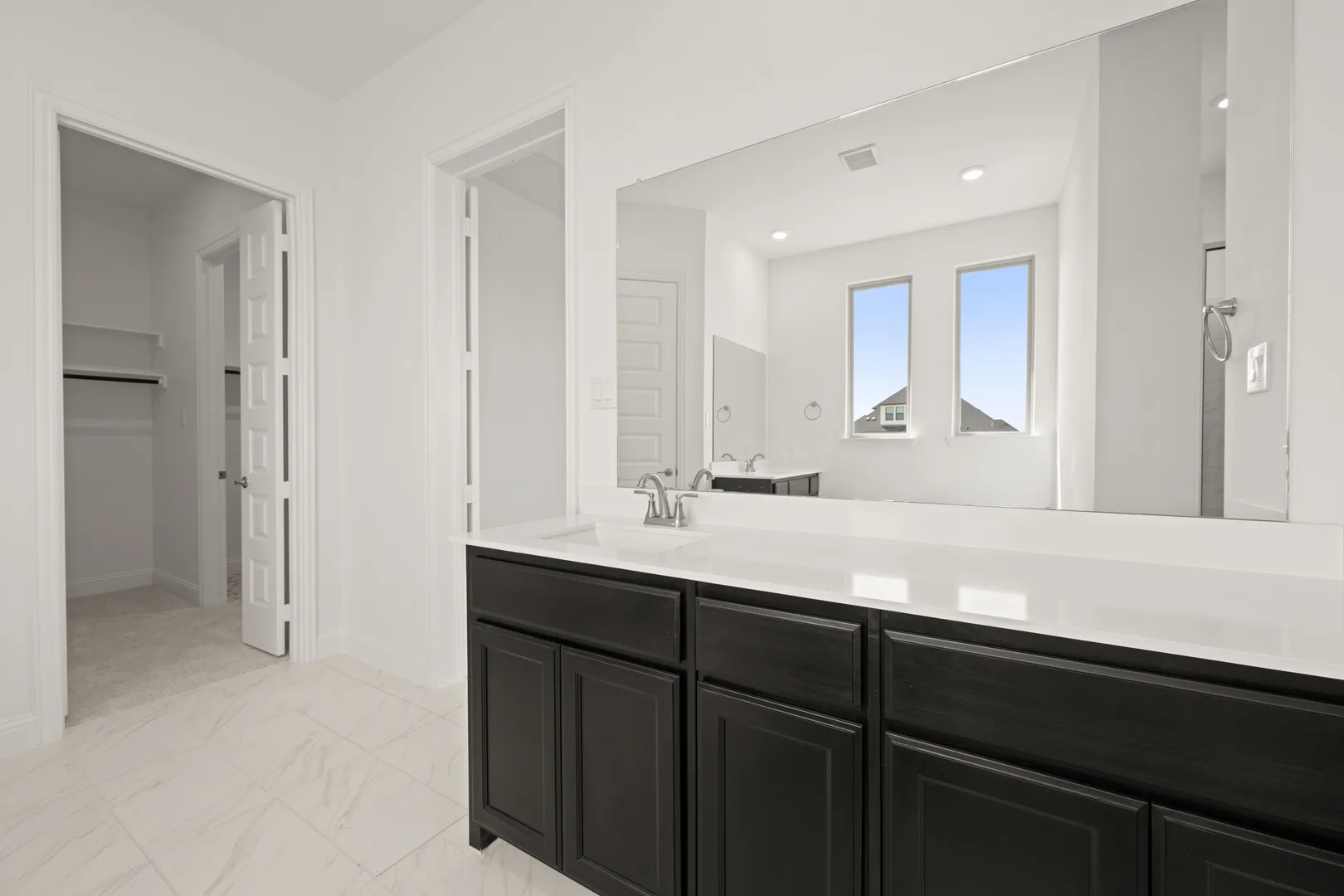 Primary bathroom with a large vanity in a modern Texas ranch style home by Kindred Homes