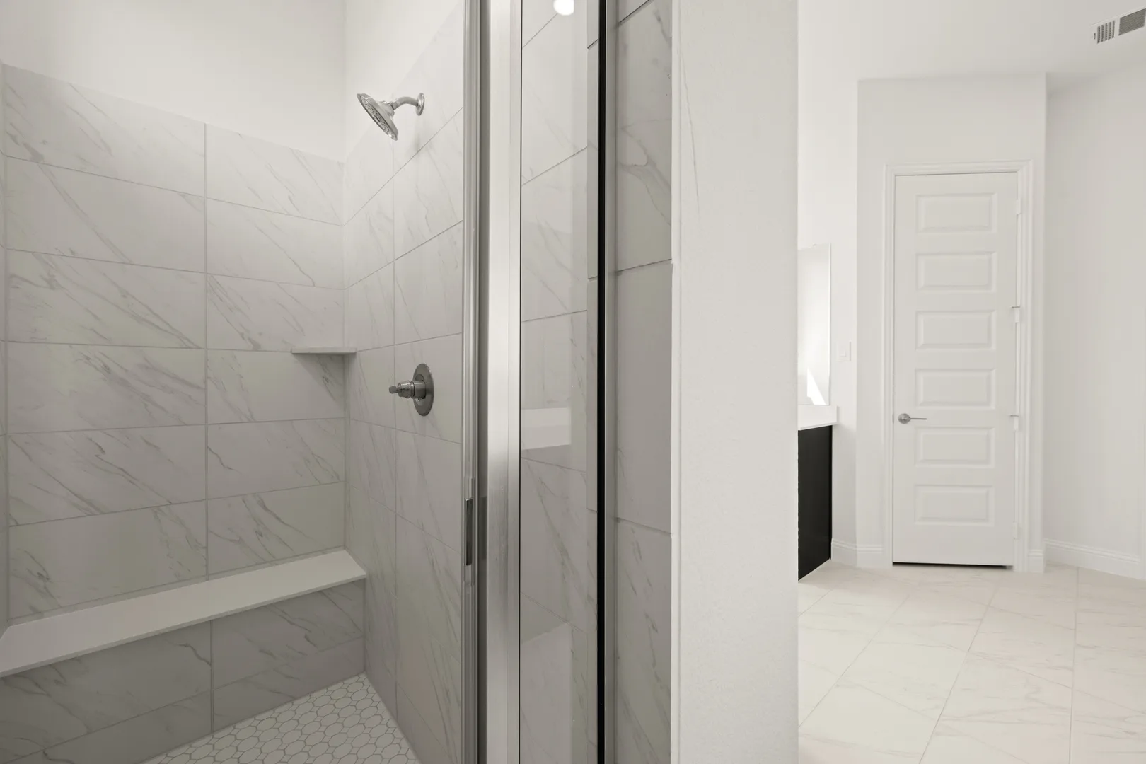 Primary bathroom with walk-in shower in a modern Texas ranch style home by Kindred Homes