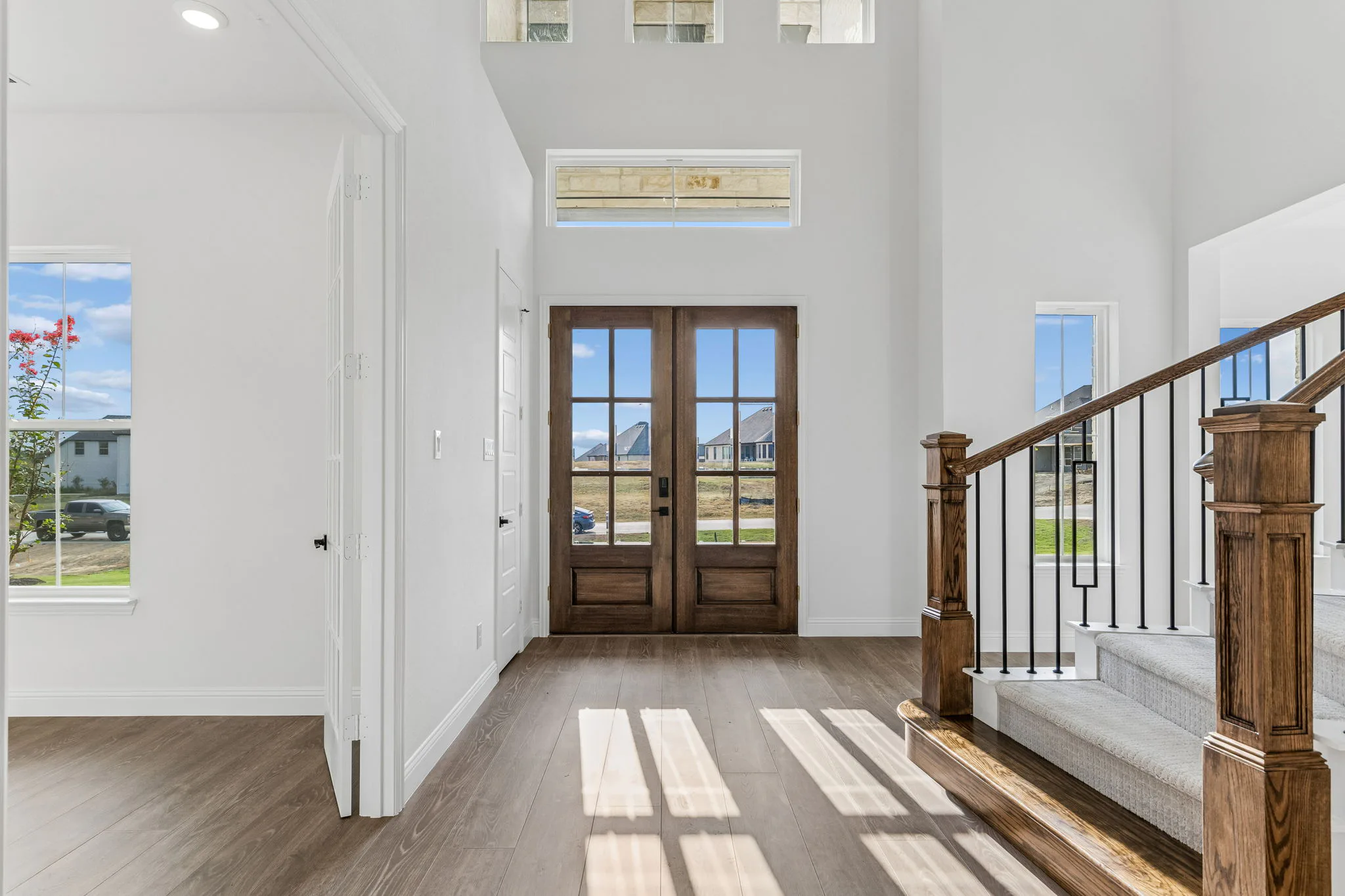 Double door entry in a transitional hill country style home by Kindred Homes.