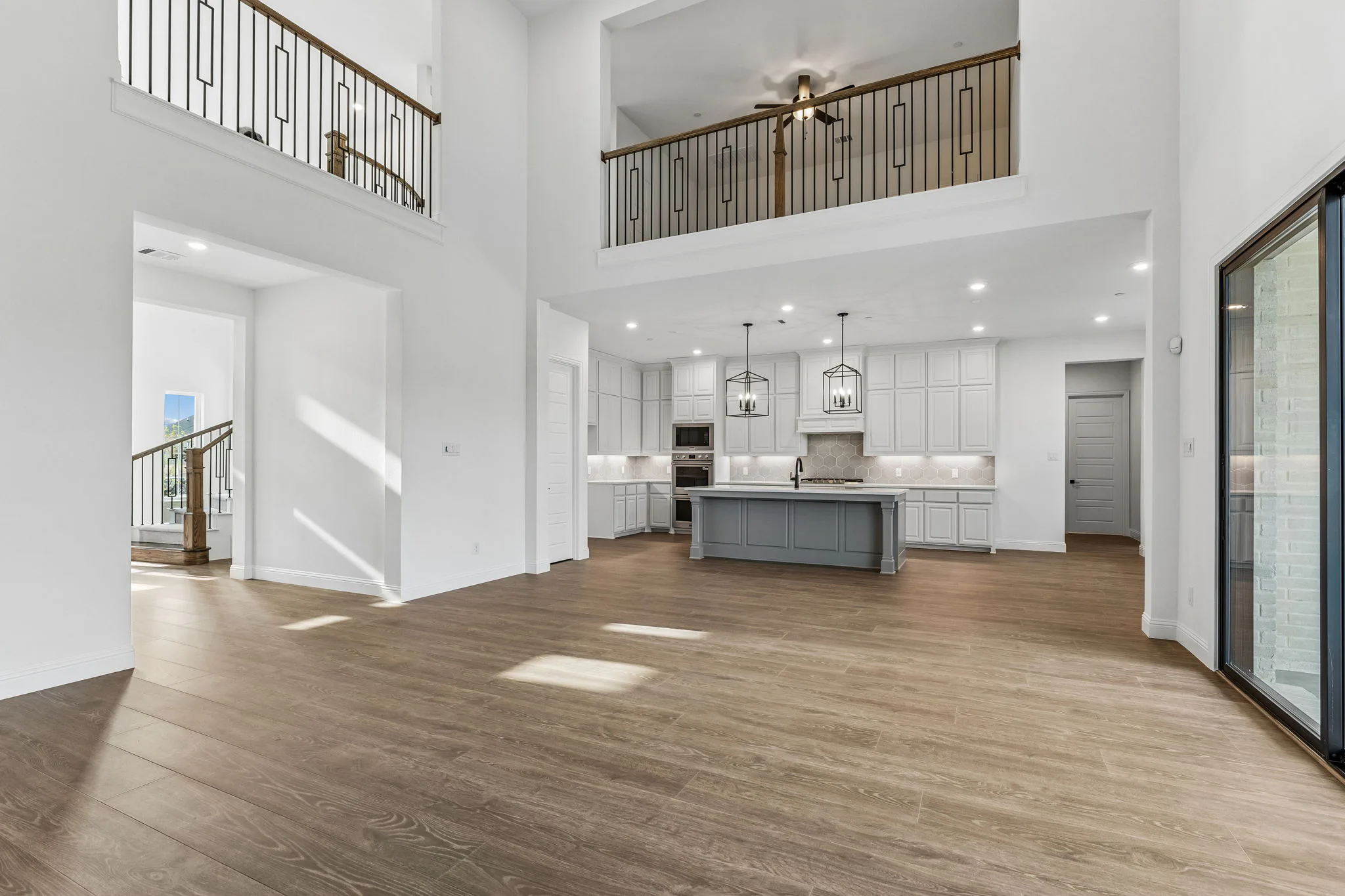 Kitchen and balcony in a transitional hill country style home by Kindred Homes.