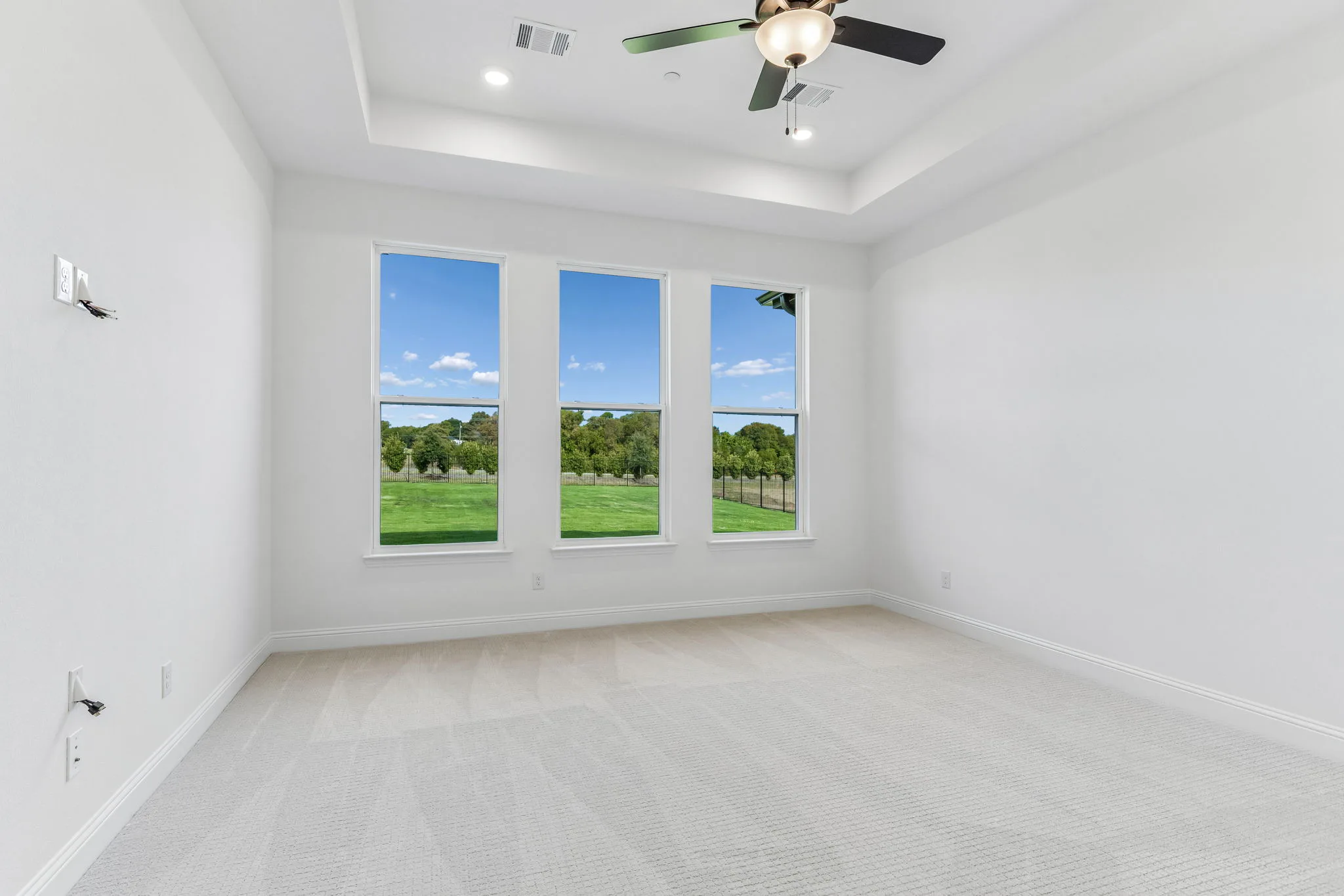 Primary bedroom in a transitional hill country style home by Kindred Homes.