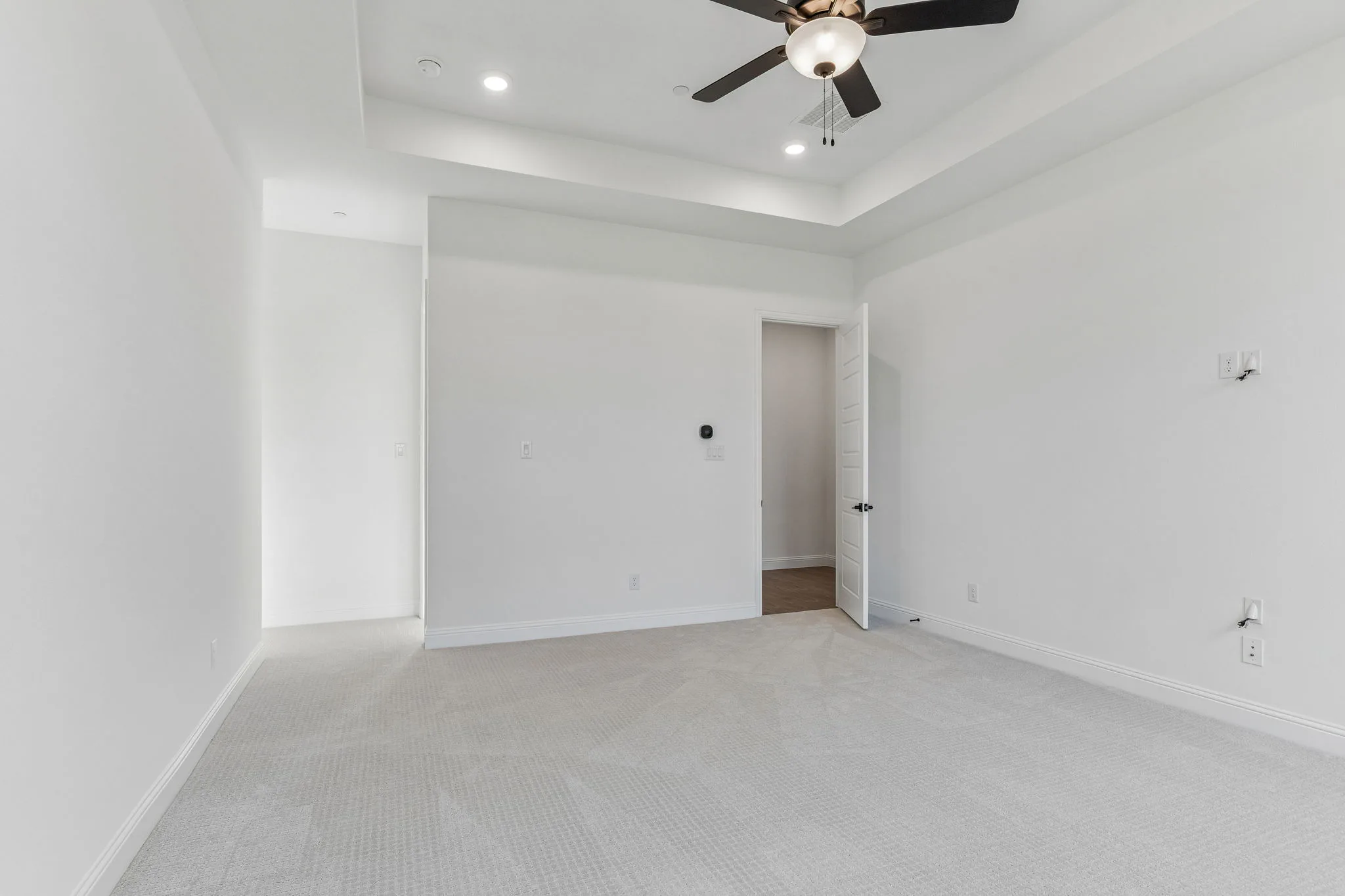 Primary bedroom in a transitional hill country style home by Kindred Homes.