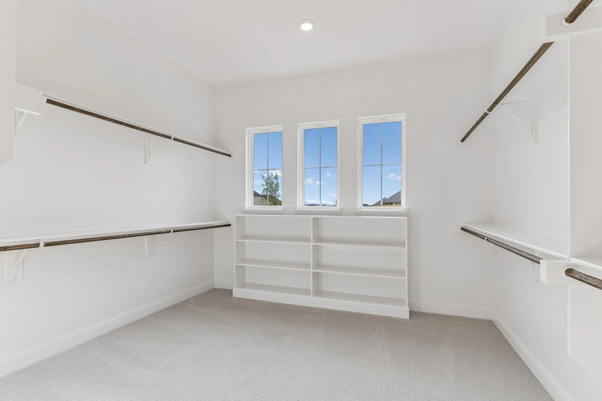 Walk-in closet with plentiful storage in a transitional hill country style home by Kindred Homes.