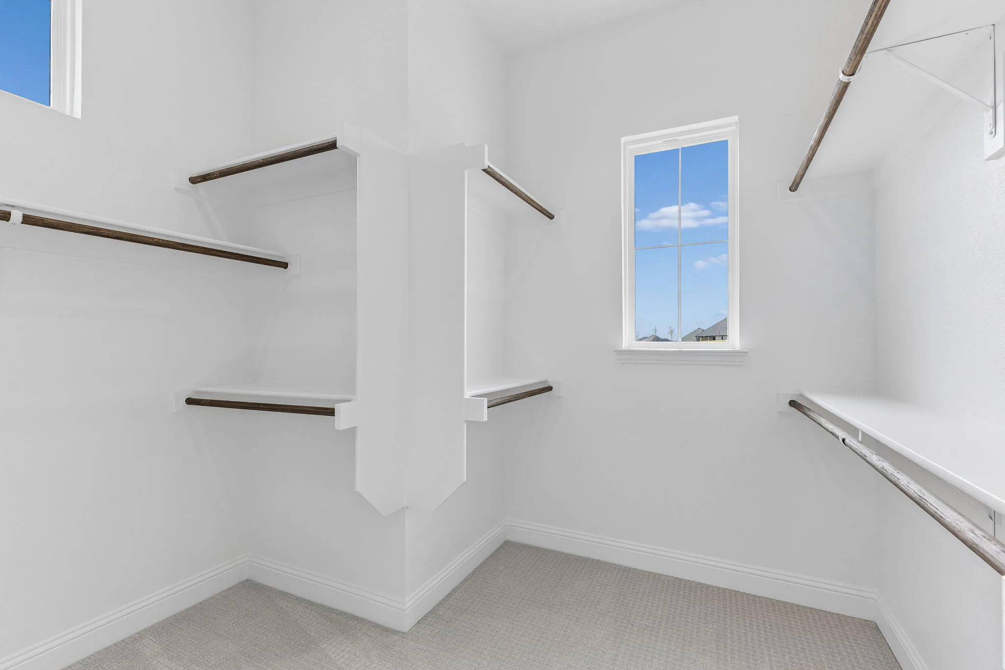 Walk-in closet in a transitional hill country style home by Kindred Homes.