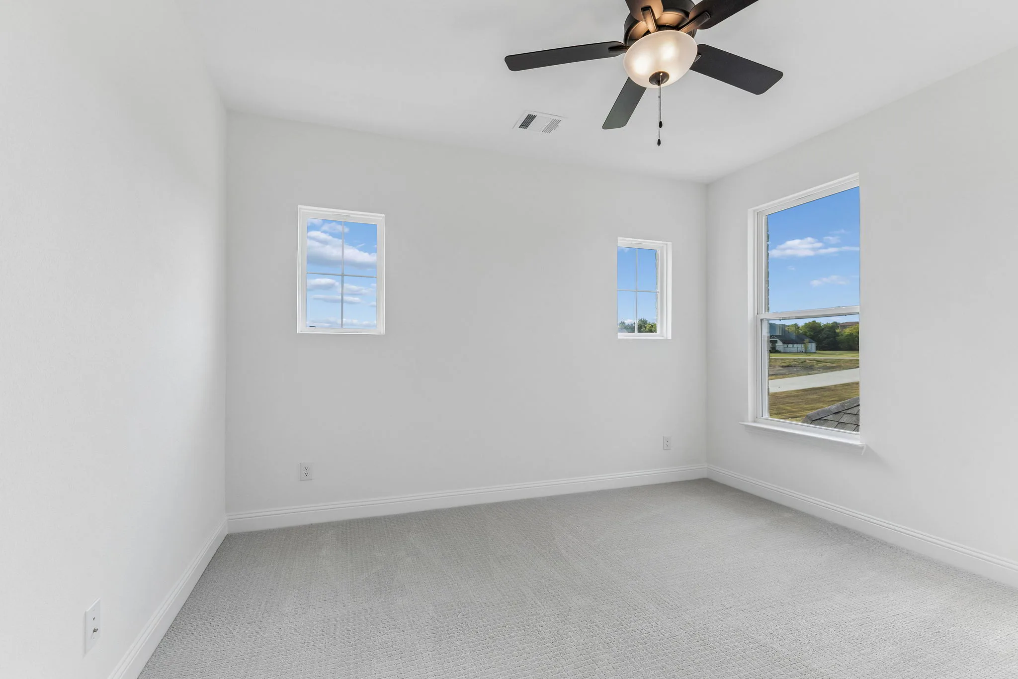 Secondary bedroom in a transitional hill country style home by Kindred Homes.