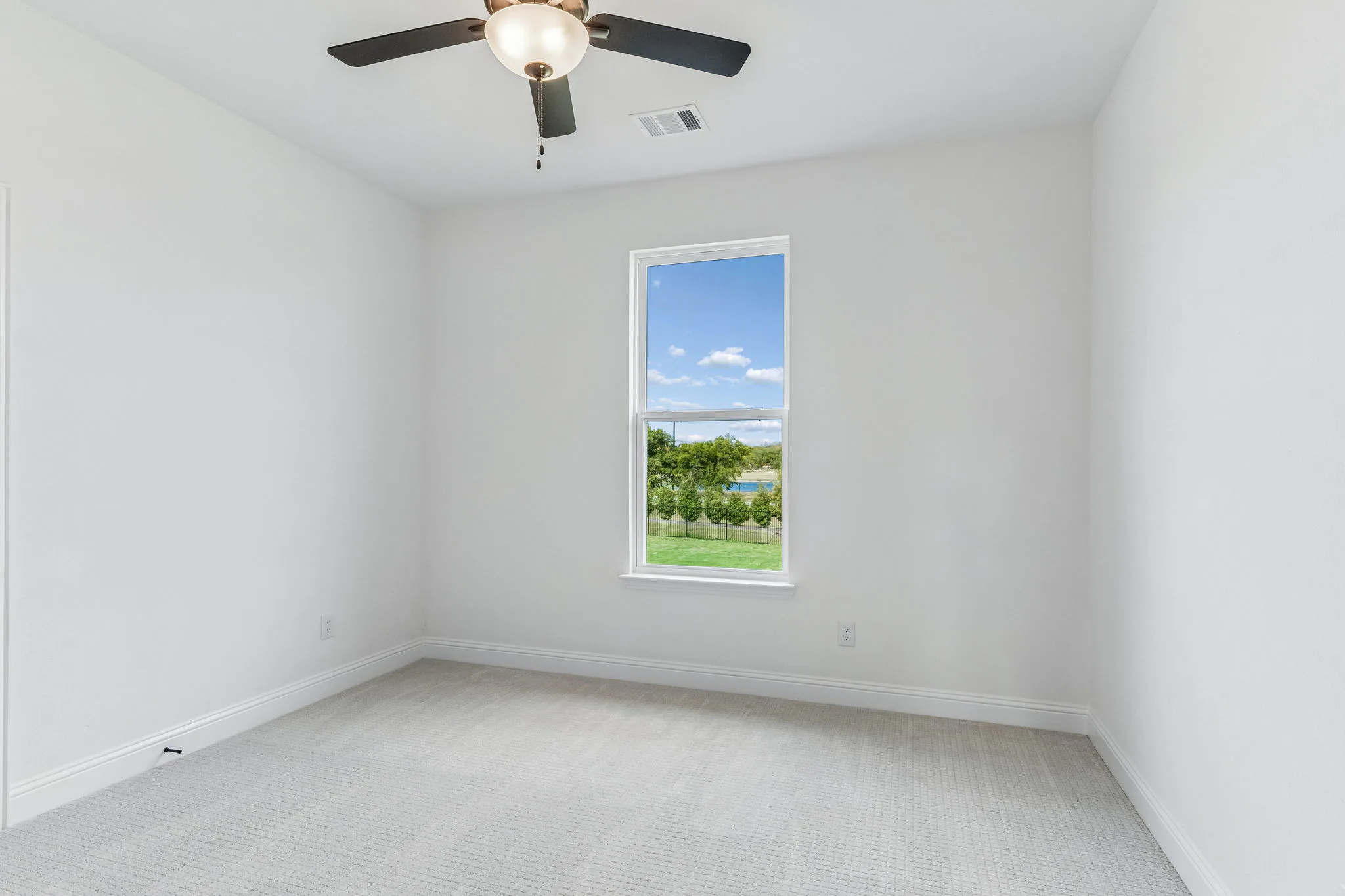 Secondary bedroom in a transitional hill country style home by Kindred Homes.