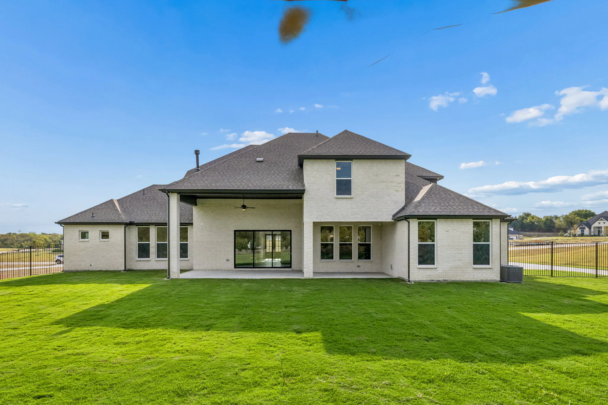 Back exterior of a transitional hill country style home by Kindred Homes.