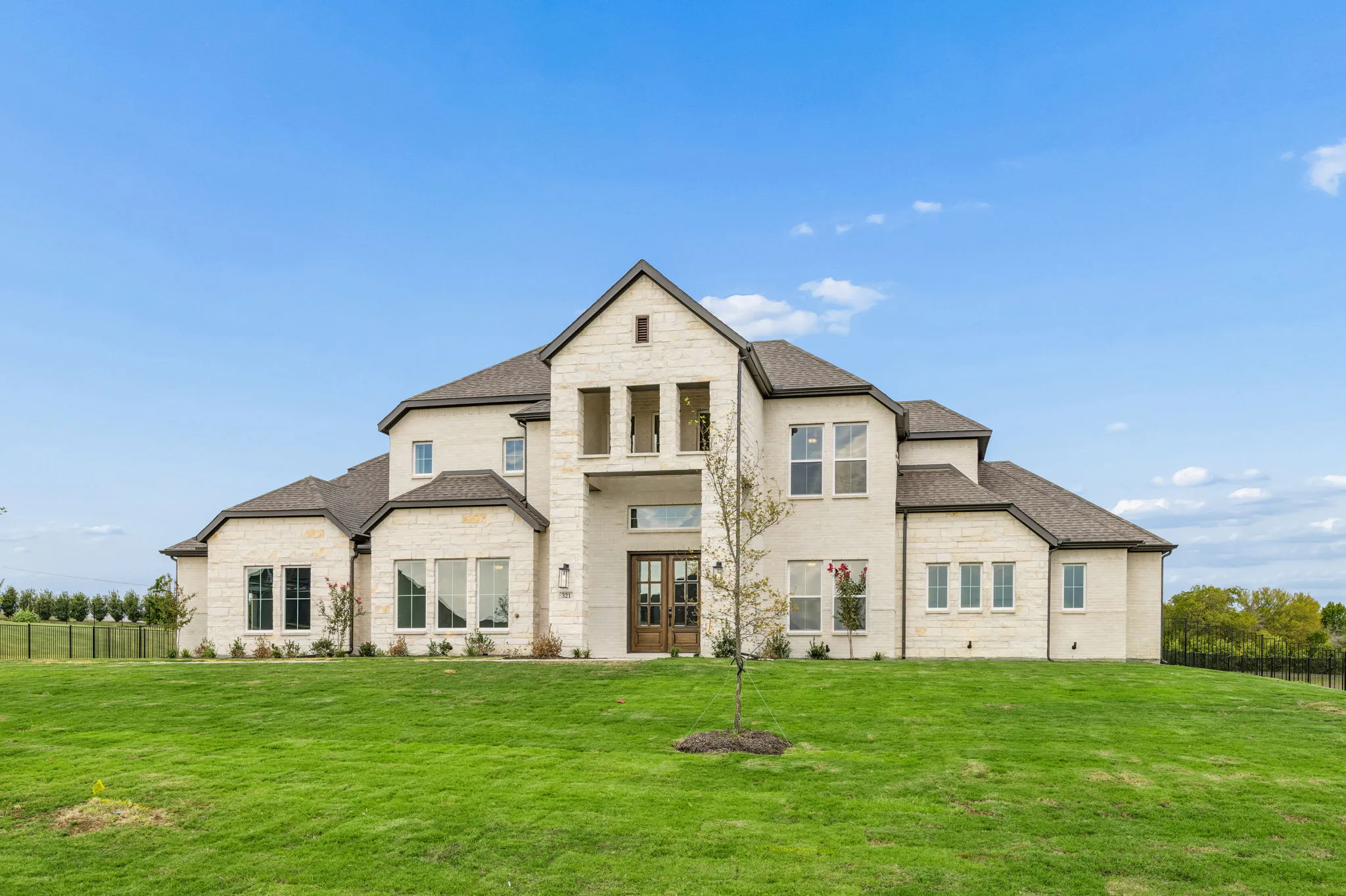Side view of the exterior of a transitional hill country style home by Kindred Homes.