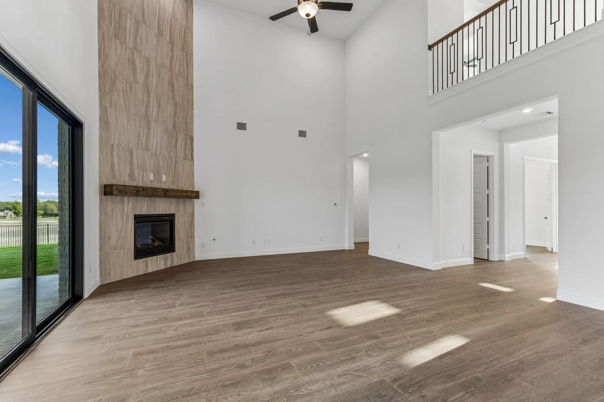 Living room with fireplace in a transitional hill country style home by Kindred Homes.