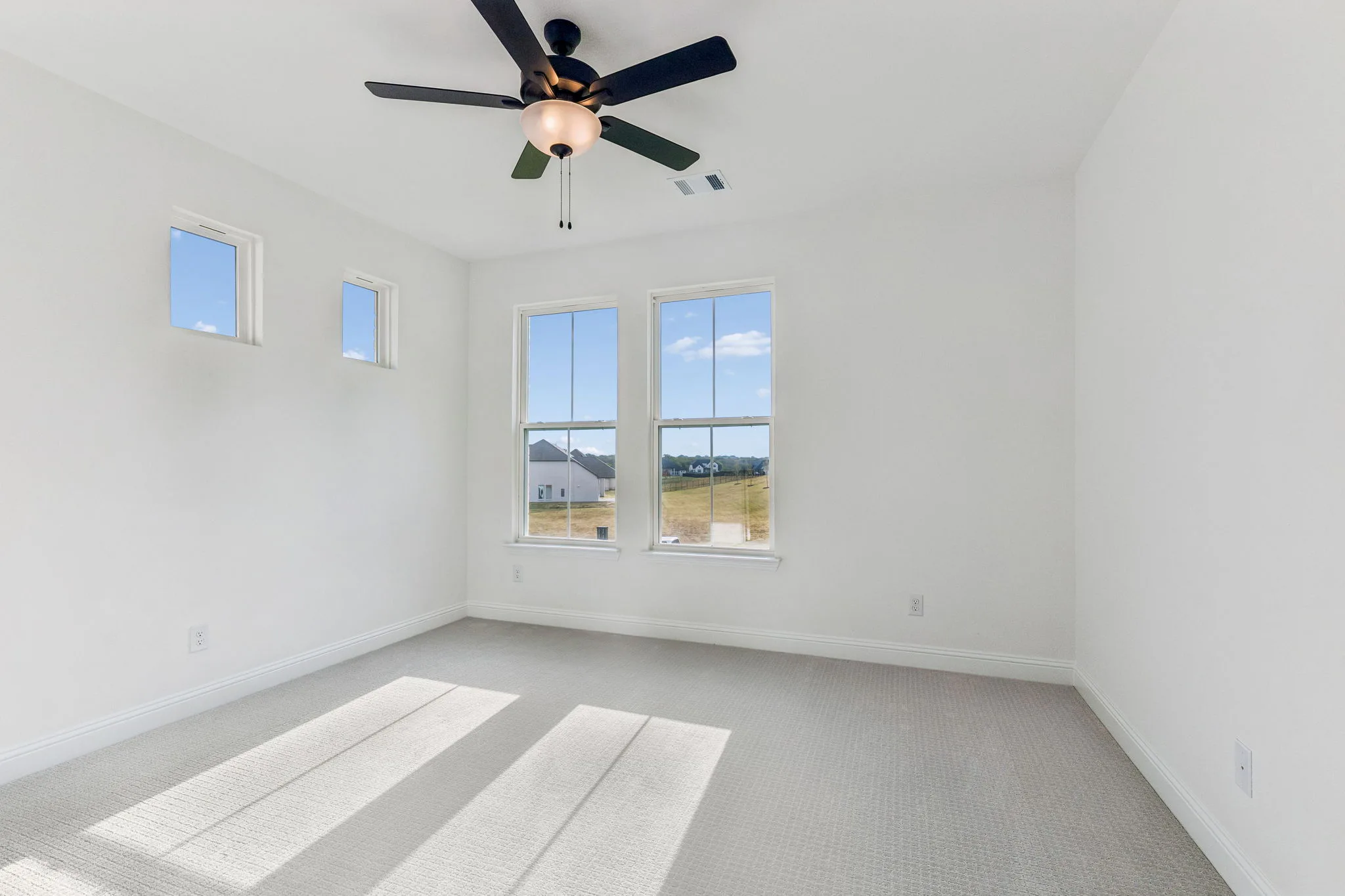 Secondary bedroom in a transitional hill country style home by Kindred Homes.