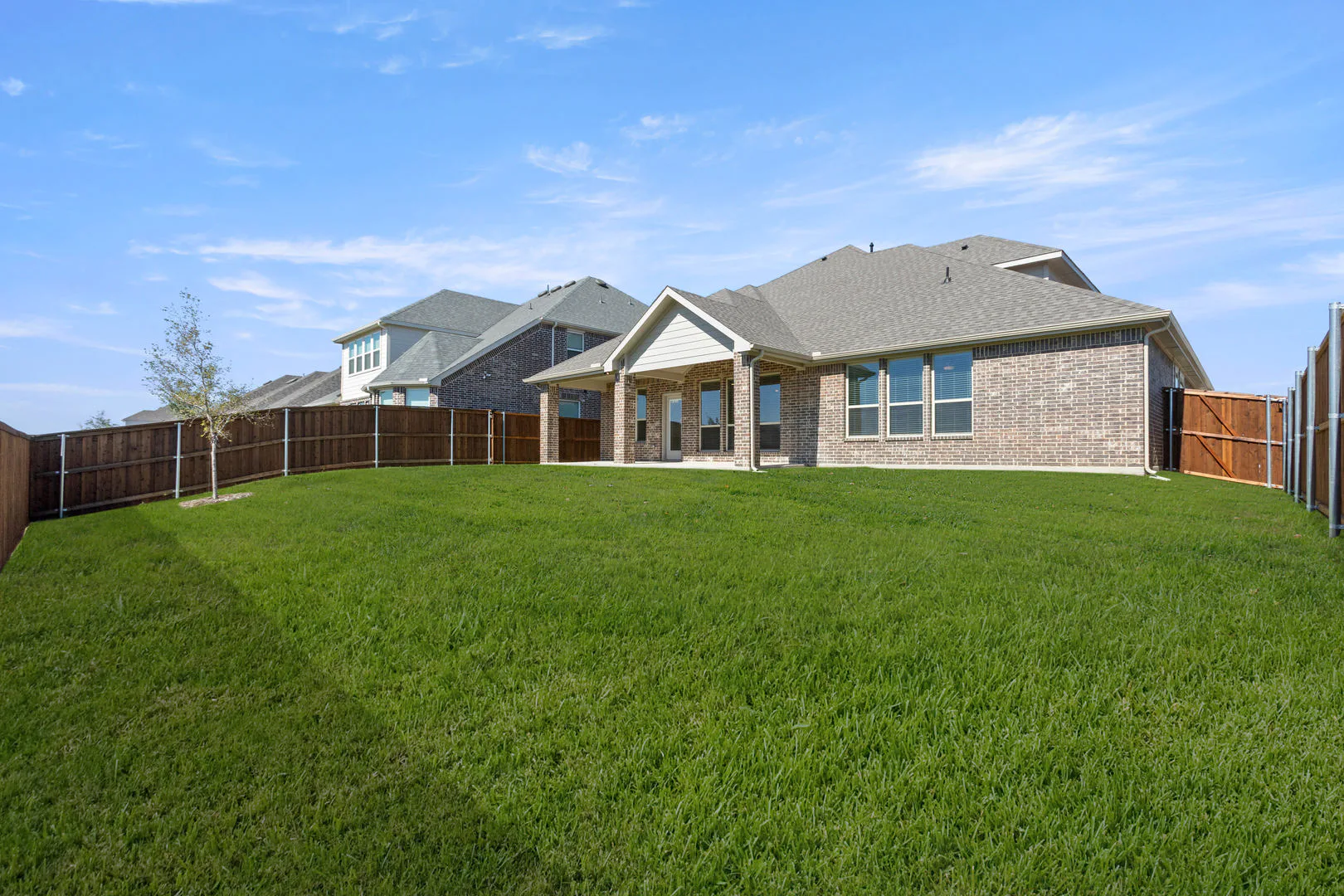 Spacious back yard of a new traditional style home by Kindred Homes