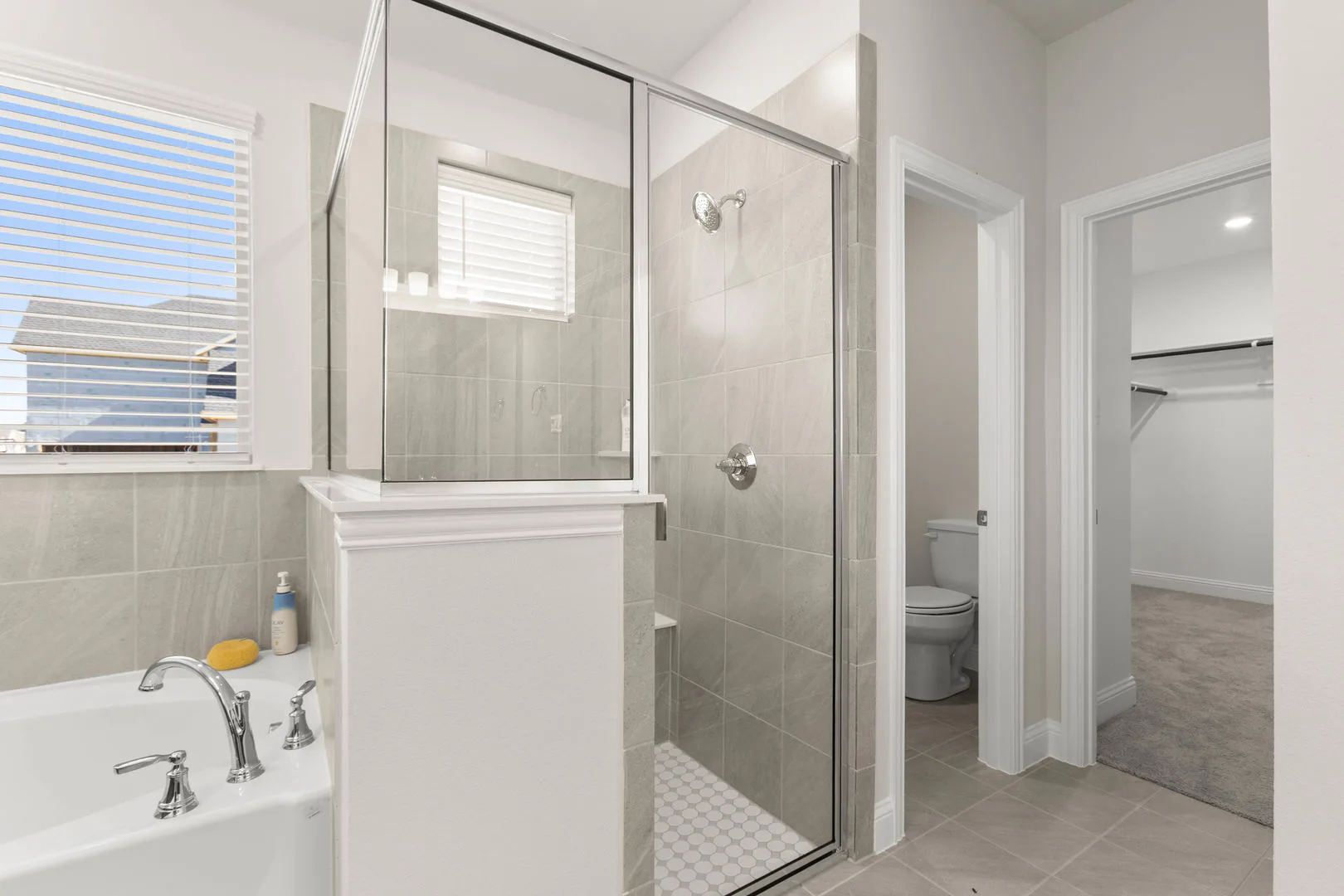 Walk-in shower in a primary bathroom in a new traditional style home by Kindred Homes